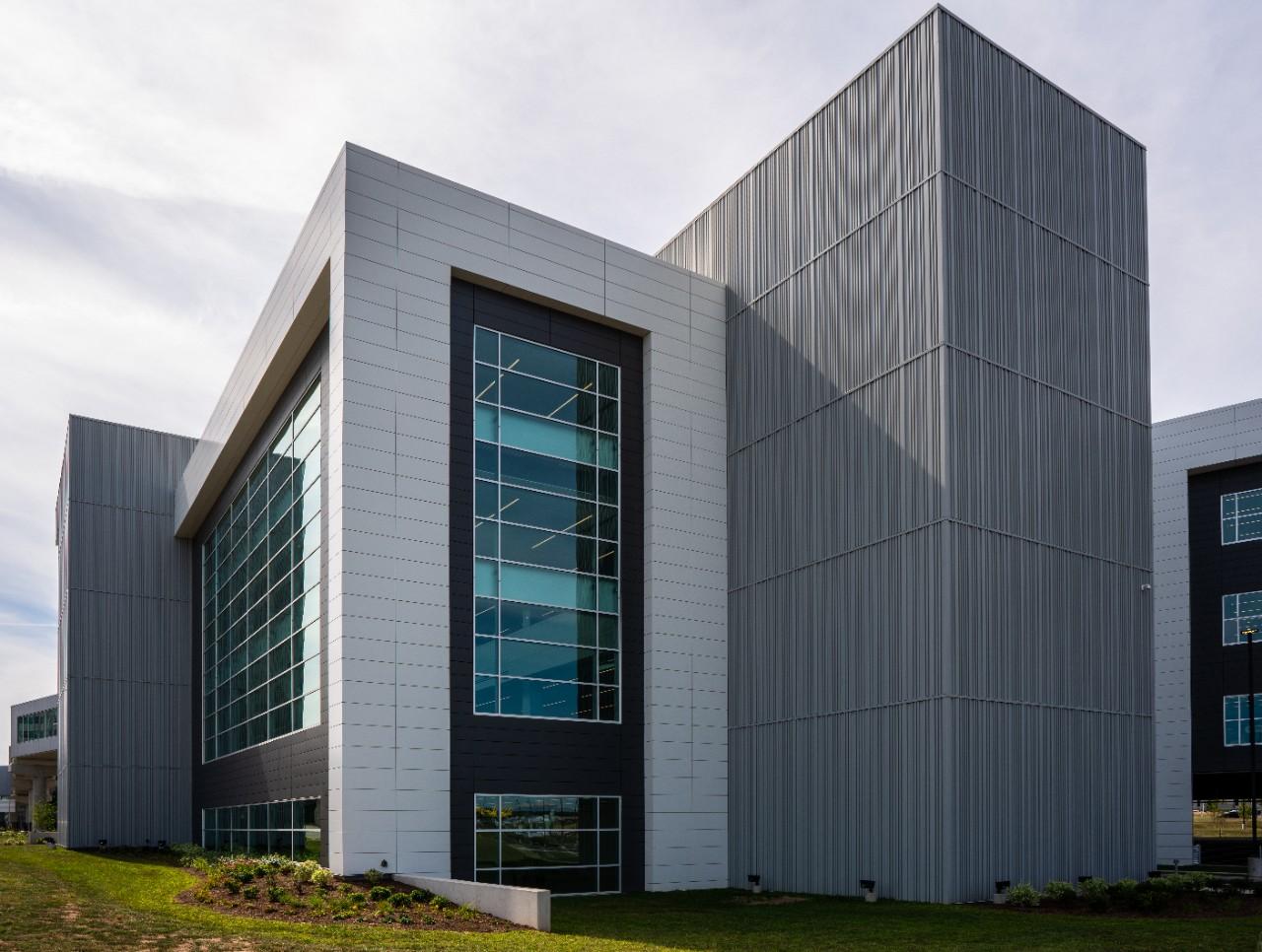 Silver panelled volumes framing a full-height glazed stair