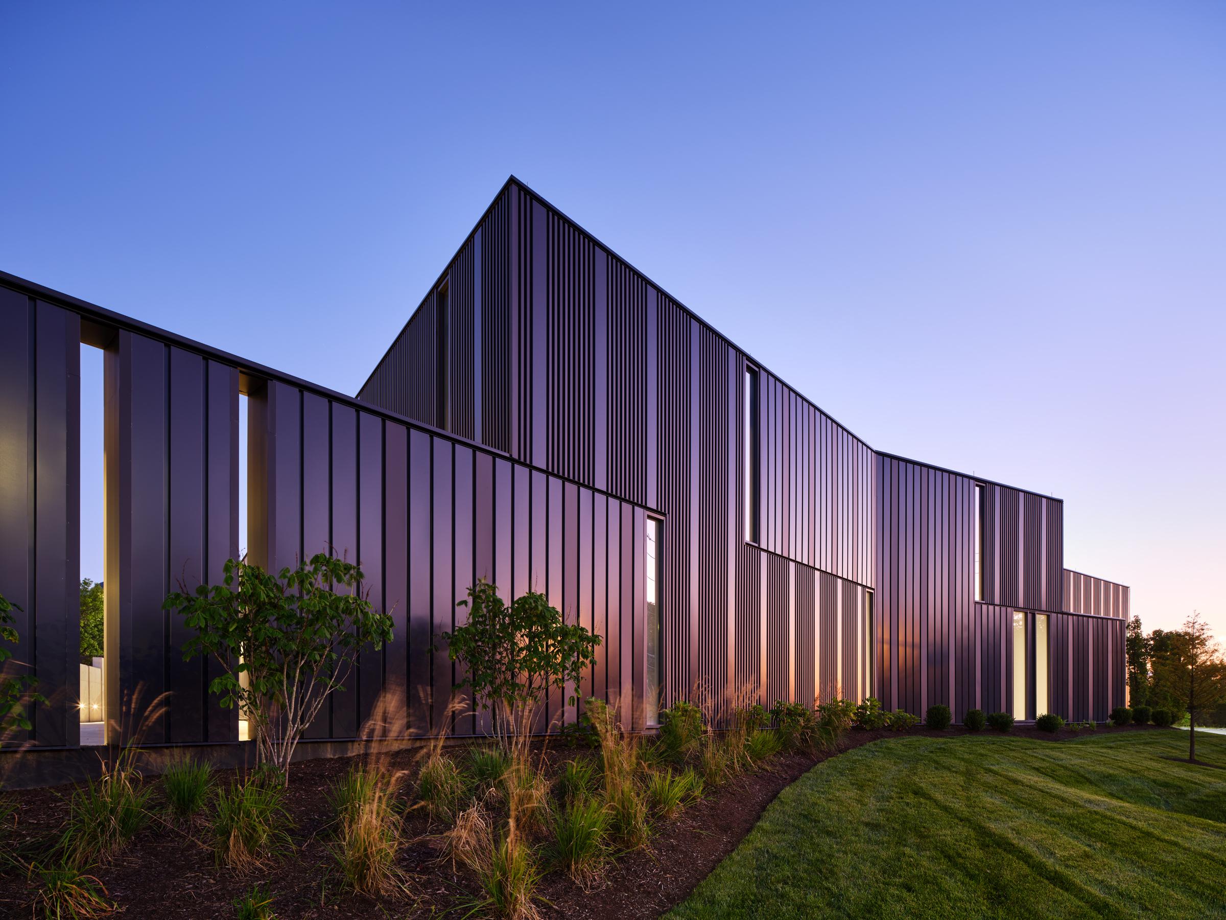 Dark ribbed façade catching the last light at dusk